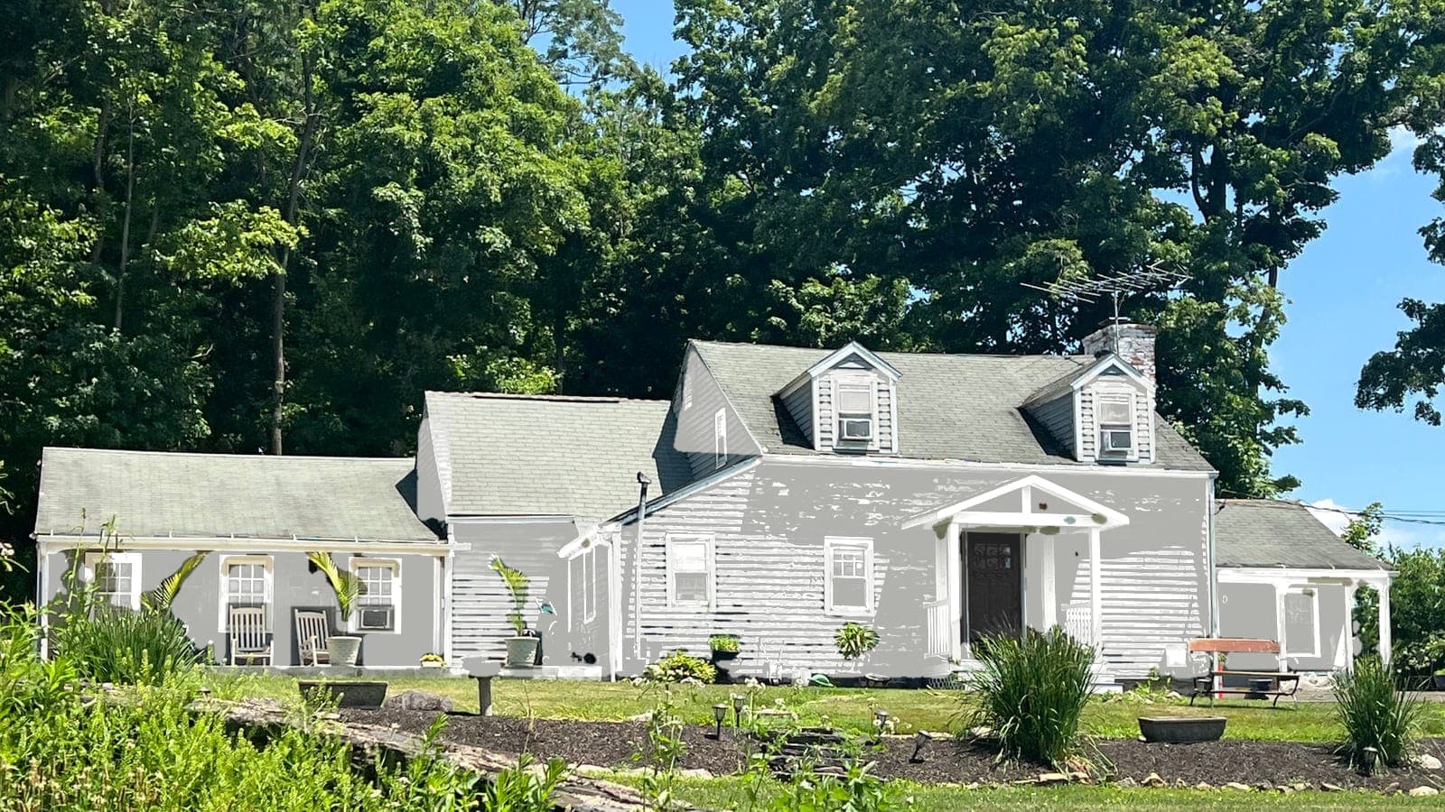 Cape Cod with lap siding and two dormers, repainted: siding Extra White SW 7006, trim Extra White SW 7006, front door Tricorn Black SW 6258