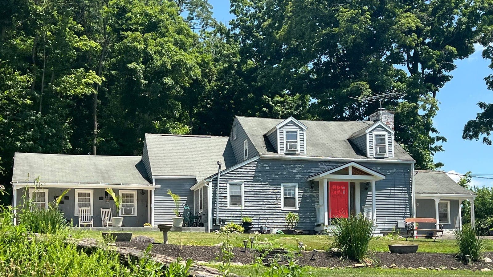 Cape Cod with lap siding and two dormers, repainted: front door Positive Red SW 6871