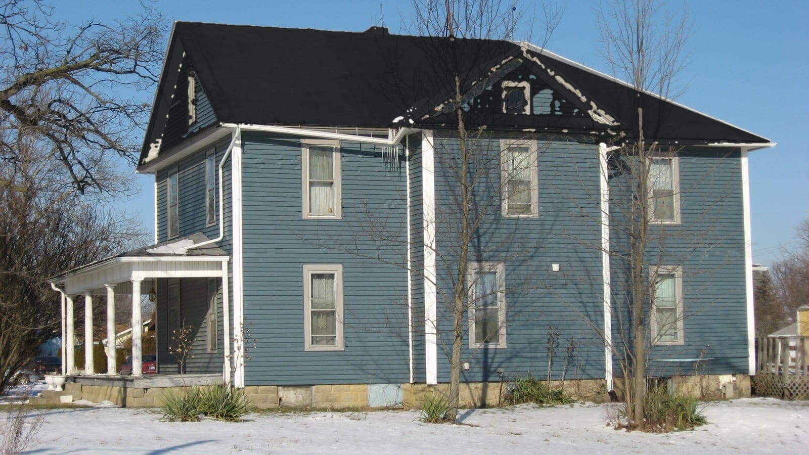 Two-story farmhouse with lap siding and a metal roof, repainted: roof Matte Black Metal (metal)