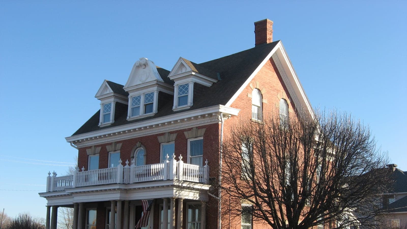 Brick colonial revival with a full-width balcony, original photo